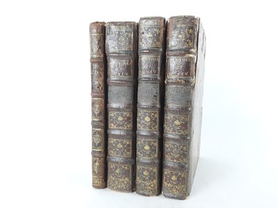three old books are stacked on top of each other on a white surface