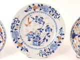 three blue and white plates with flowers and birds on them