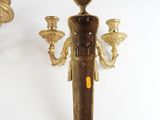 pair of antique brass wall sconces with candle holders on a white background