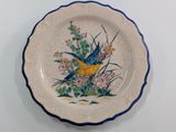 a plate with a bird painted on it sitting on a table