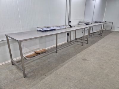 une longue table dans une pièce où se trouvent de nombreuses tables