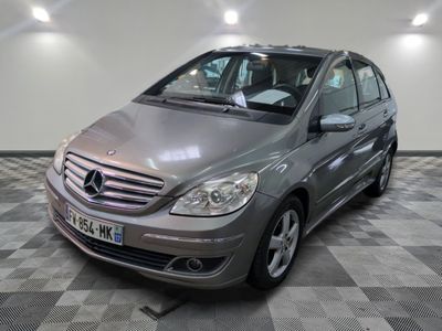 La Mercedes Classe B est garée sur un sol à damier dans un garage