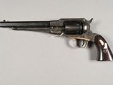 an old revolver with a wooden handle on a white surface