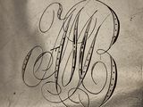 a close up of a monogram on a silver plate