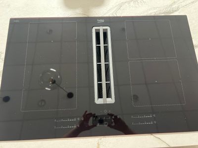 une plaque de cuisson noire surmontée d'un brûleur en verre