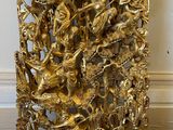 gold sculpture of a group of animals in a frame on the floor