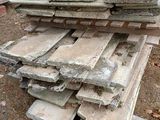 un tas de briques posé par terre à côté d'un bâtiment