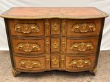une image représentant une commode en bois ornée de motifs dorés