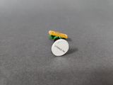 a close up of a small pill on a table next to a pencil