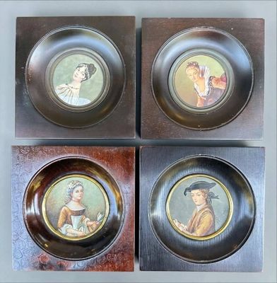 trois assiettes ornées de portraits, posées sur un support en bois
