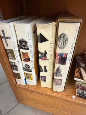 Plusieurs livres sont empilés sur une étagère devant une porte