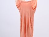 pink dress hanging on a hanger in front of a white wall