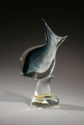 a glass sculpture of a fish on a clear base