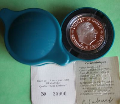 a blue bowl with a coin in it next to a receipt