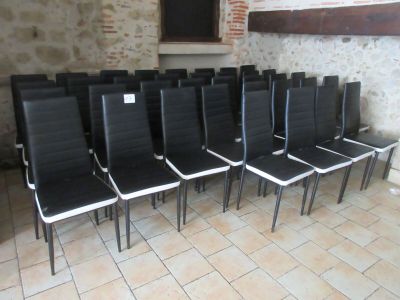 des rangées de chaises noires et blanches dans une pièce aux murs en briques