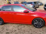 the red car is parked in the parking lot next to other cars