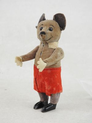 un petit ours en peluche qui porte une jupe rouge