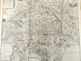 an old map of paris in a book on a table