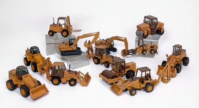 de nombreux engins de chantier miniatures posés sur une surface blanche