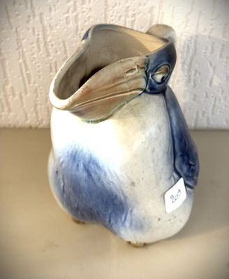 un vase bleu et blanc surmonté d'un oiseau