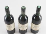 three bottles of wine sitting next to each other on a white surface