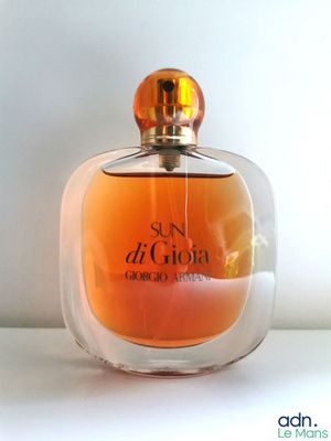 an image of a bottle of perfume sitting on top of a table