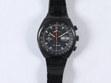 a black watch on a black bracelet on a white surface