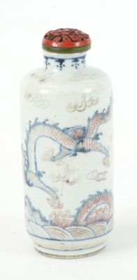 a white and blue vase with a dragon design on it