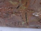 a close up of a sculpture of a cross on a piece of metal