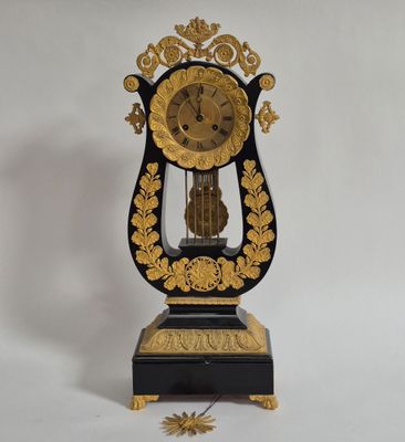 une horloge noire et or posée sur une surface blanche