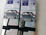 packaging of two silver luggage bags sitting on top of a white table