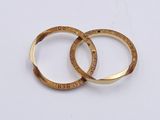 two gold rings that are sitting on a white surface