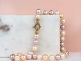 a close up of a necklace with pearls on a marble block