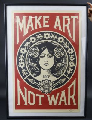 une personne brandissant une affiche sur laquelle on peut lire « Make art, not war »