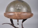 un casque métallique posé sur un support muni d'une base en bois