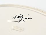 a close up of a white plate with a signature on it