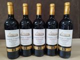 six bouteilles de vin rouge sont alignées sur une table