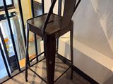 un tabouret de bar en métal placé devant une fenêtre