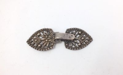 an image of a pair of silver metal buttons on a white surface