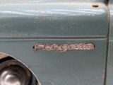 a close up of a green truck with a metal emblem on it