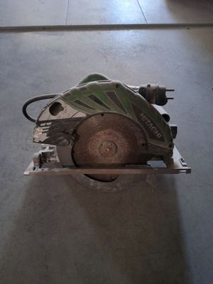 quelqu'un utilise une scie circulaire pour couper une pièce de bois