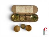 une boîte en bois contenant trois verres et une pièce de monnaie