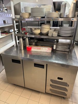stainless steel counter top in a commercial kitchen with dishes stacked on it