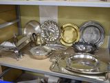une étagère sur laquelle sont disposés de nombreux plats en argent