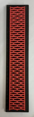 a red and black comb sitting on a white surface