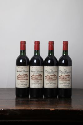 quatre bouteilles de vin sont alignées sur une table en bois