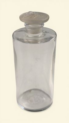 a clear glass jar with a wooden lid on a white surface
