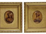 deux portraits encadrés représentant un homme et une femme, dans un cadre doré