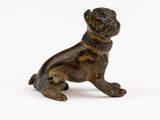 une statue en bronze représentant un chien portant un collier autour du cou