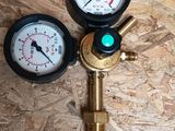 two pressure gauges on a wooden surface with a green light